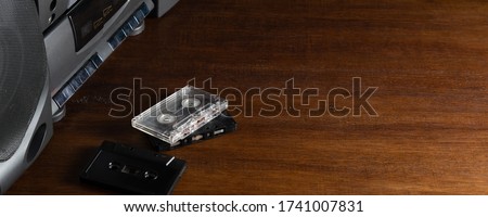 Old audio cassettes and a player on a wooden table. Copy space for text or design