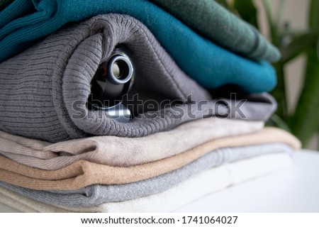 Webcam hidden in a stack of clothes for covert surveillance of the house. Surveillance and security systems. Smart House. Espionage. Hidden camera for watching Royalty-Free Stock Photo #1741064027