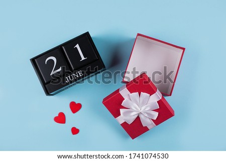 Open empty gift box and wooden calendar date 21 june on blue background. Father's day concept. Flat lay, top view. Mockup, place for object