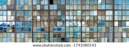 Grunge background of old shop windows of an inactive factory room, traces of aging glass, cracks. Reflections of the blue sky. Aspect ratio 3 to 1. Royalty-Free Stock Photo #1741080143