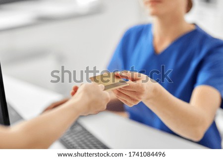 medicine, people and healthcare concept - close up of patient giving female doctor or nurse insurance or credit card card at hospital Royalty-Free Stock Photo #1741084496