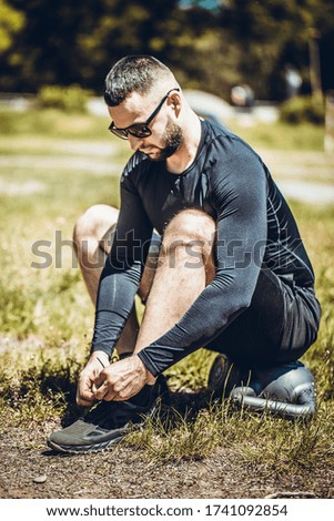 Close up photo of runner man tying running shoes laces. Working out cardio or lose weight concept. 
