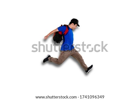 Picture of college student jumping in studio while carrying backpack, isolated on white background 