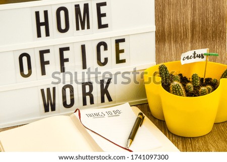 lightbox with text HOME OFFICE WORK with notebook pen and cactus and TO DO list, copy space wooden table background, quarantine and isolation HOME OFFICE, coronavirus, europe