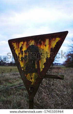 triangular railway sign, very old and rusty. in the German village.