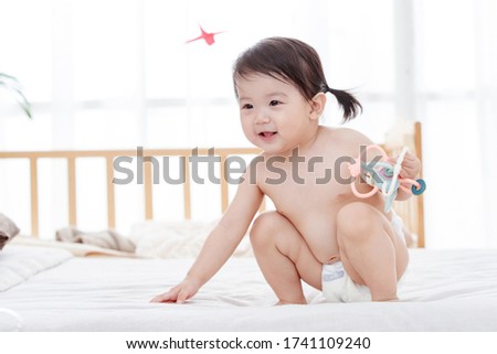 Baby sitting on the bed to play
