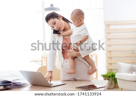 Young mother holding the children work at home