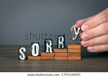 SORRY. Forgiveness, understanding, empathy and kindness concept. Wooden alphabet letters on steps. Gray background
