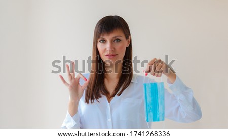 Caucasian young woman with respiratory mask approving protective mask for prevent infection and showing sign ok. Medical concept protection from outbreak Covid 19 virus, cold, flu, respiratory disease