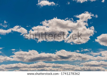 Summer cloudy blue sky background. Panoramic view with beautiful clouds. Horizontal cloudscape. High-resolution photography. Design element. Copy space.