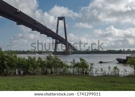 Large bridge over Mississippi river in Louisiana on bright sunny day with clouds