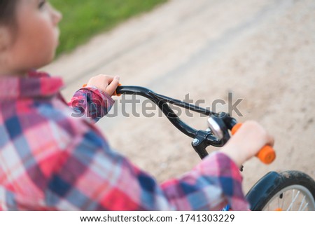 cute little girl riding a bike on beautiful nature. A child plays sports bike ride 