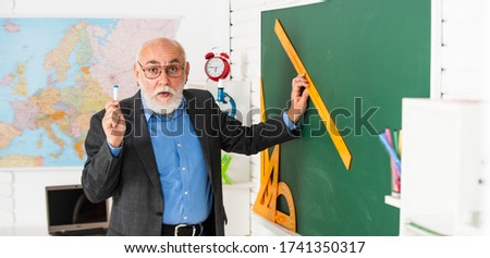 good idea. high school modern education. senior man teacher use ruler while drawing. tutor man in glasses draw with ruler on blackboard. back to school. what angle you look. geometric shapes.