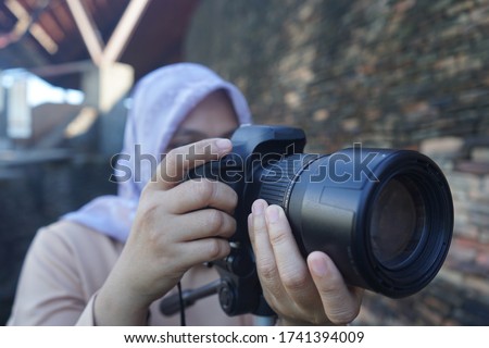 Muslim women take pictures using a DSLR camera