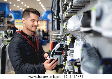 Young man looking for sports equipment at sports shop