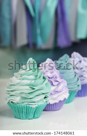 row of cupcakes in aqua and purple