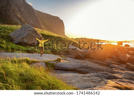 Woman traveler on the seashore at sunset on Lofoten islands in Norway. Bright beautiful landscape. northern nature