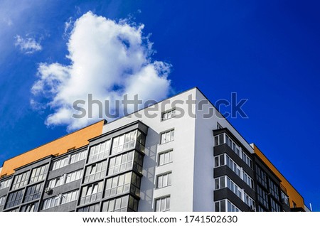 Apartment building on background of blue sky with clouds