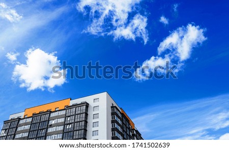 Apartment building on background of blue sky with clouds