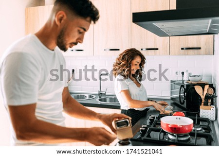 Lifestyle couple cooking at home. The girl is making the pasta and the boy is making coffee in the coffee pot.