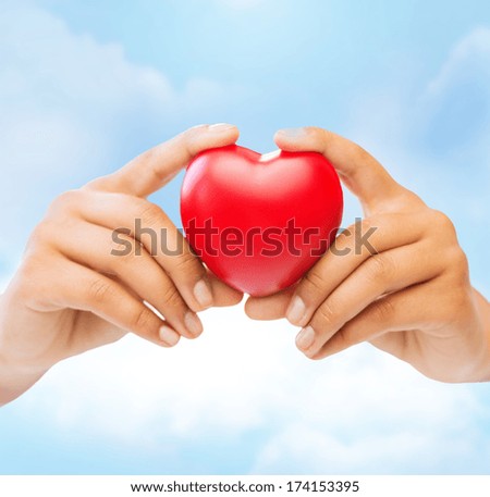 health and charity concept - closeup of female hands holding heart