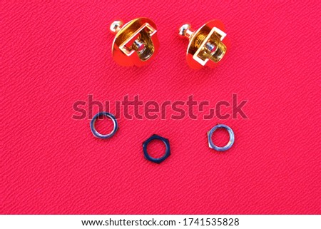 Gold streplop for a guitar are on a red background with copy space. Accessories for the guitar. Smile from the accessories for the guitar.