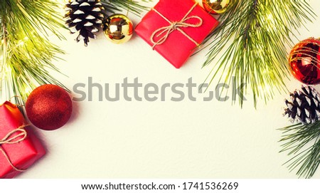 Background for the New Year, Christmas. Christmas toys and conifer branches. Gift in red paper, white cone. Place for text.
