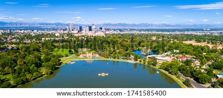 city park and lake views with Denver Colorado skyline cityscape in the background with Rocky mountains during sunny day time afternoon 