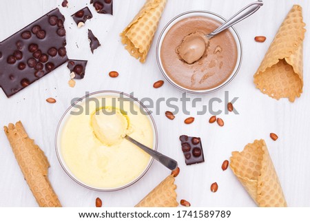 Homemade ice cream with banana, chocolate, nuts with cones. Flat lay, background.