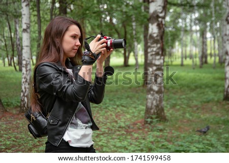 A girl with a camera in nature in a Park in the forest photographing animals a beautiful Park a man with a camera