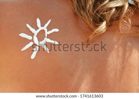 happy girl on the sea with a picture of the sun on her back
