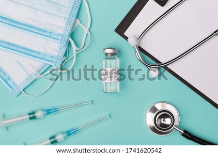 New coronavirus vaccine testing prescribing medicine concept. Top above overhead view photo of vaccine vial masks stethoscope shots and clipboard isolated on blue background