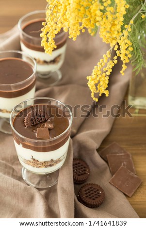 Service chocolate magnolia dessert with hazelnut on the wooden background.
