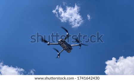 Latest technology drone or UAV shot in clear blue sky with some clouds