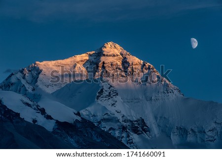 close up view of moon and mount Qomolangma in golden color in a tranquil sky at night