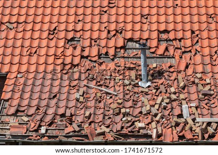 storm damage to a tiled roof, destroyed roof tiles, Ceramic roof tiles Royalty-Free Stock Photo #1741671572