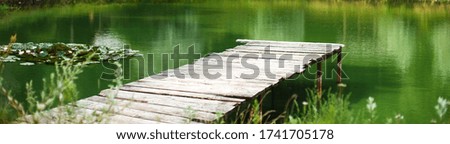 Wooden dock, pier on a lake in summer day. banner