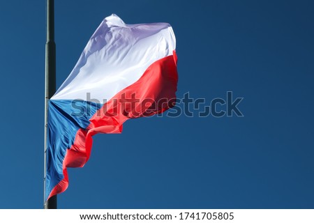 A lowered Czech flag flutters in the wind.