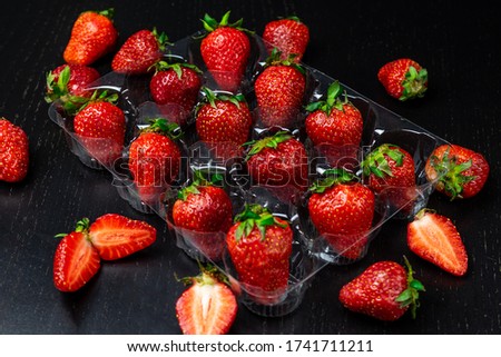 A lot of fresh strawberries on dark background. Top view. Concept of healthy fruits.