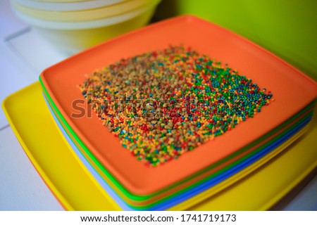 
Developing lessons for young children. The development of fine motor skills. Buckwheat is mixed with colored rice in a colored plastic bowl. Natural toys. Kindergarten.
