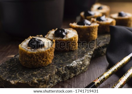Traditional salmon fish hot roll with tare sauce  in a rustic granite platter in wood background Royalty-Free Stock Photo #1741719431