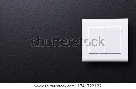 The double wall switch of white color on a black background.