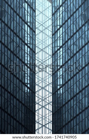 Double exposure photo of glass walls. Sky reflecting in high-rise building. Abstract modern architecture of skyscrapers in financial business city. Material background with pattern of windows.