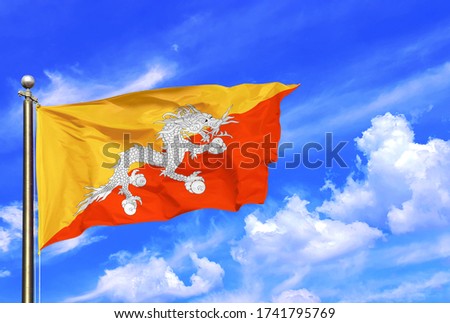 The National Flag Of Bhutan Yellow Orange White Dragon Waving In The Wind On A Beautiful Summer Blue Sky Royalty-Free Stock Photo #1741795769