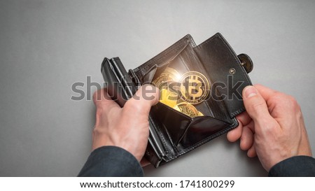 Cryptocurrency coin bitcoin in a black wallet. Bitcoin accumulation, trading sell and buy concept. Cryptocurrency saving symbol. Royalty-Free Stock Photo #1741800299