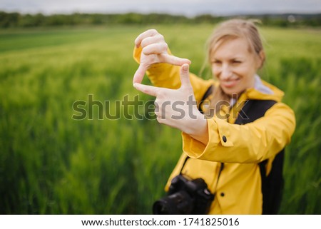 Woman looking for shooting composition through fingers frame
