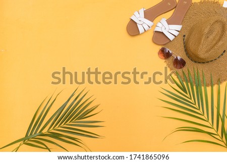 Summer vacations concept ,Sun straw beach hat with eyeglasses and tropical palm on yellow. t. Top view

