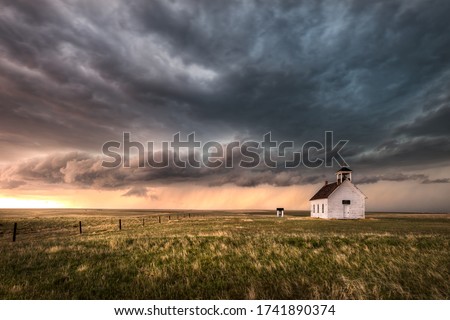 A severe thunderstorm approaches an old abandoned church in the countryside during the late afternoon in Colorado.  Royalty-Free Stock Photo #1741890374