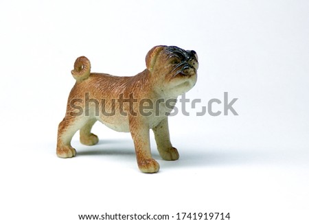 The puppy is isolated on a white background. A Sheepdog puppy on a white background. Statuette of a puppy.