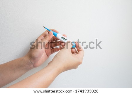 Woman hands holding a digital thermometer